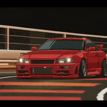 A Red Car Is Driving On A Road With A Fence In The Background GIF