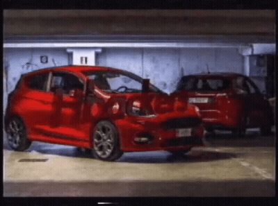 A Red Car Is Parked In A Garage With The Number 11 On The Wall Behind It GIF