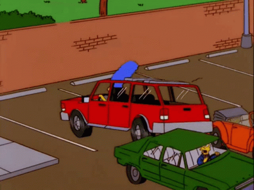 A Red Car Is Parked In A Parking Lot With A Green Car Next To It GIF
