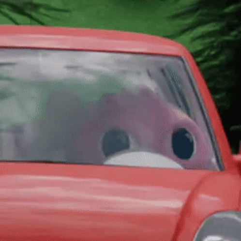 A Red Car With A Pink Flamingo In The Driver 'S Seat .. GIF