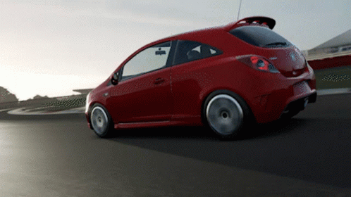 A Red Car With The Word Corsa On The Back Is Driving Down A Road GIF