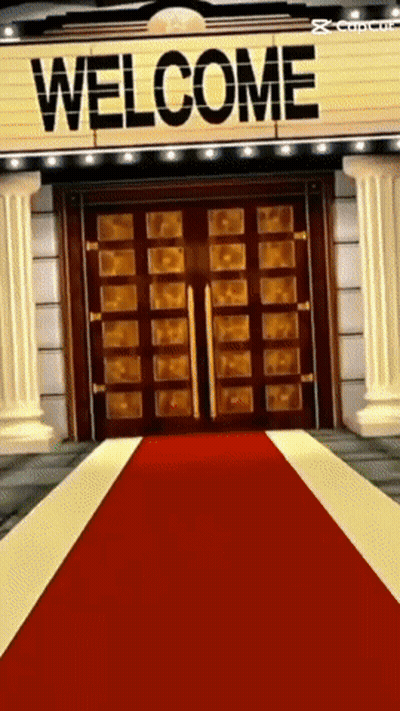A Red Carpet Is Leading To A Large Welcome Sign GIF