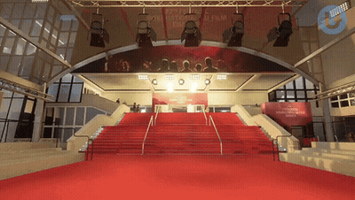 A Red Carpet Leading Up To A Stage With A Sign That Says " Cannes " GIF