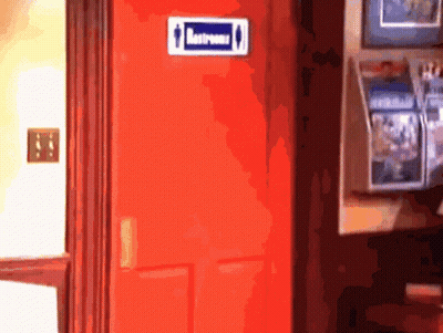A Red Door With A Blue Sign On It That Says Restrooms GIF