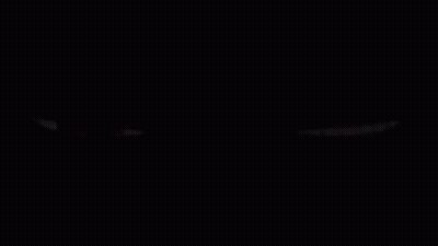 A Red Eye And A Purple Eye Are Glowing In The Dark On A Black Background . GIF