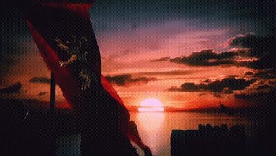 A Red Flag With A Lion On It Is Flying In Front Of A Sunset Over A Body Of Water GIF