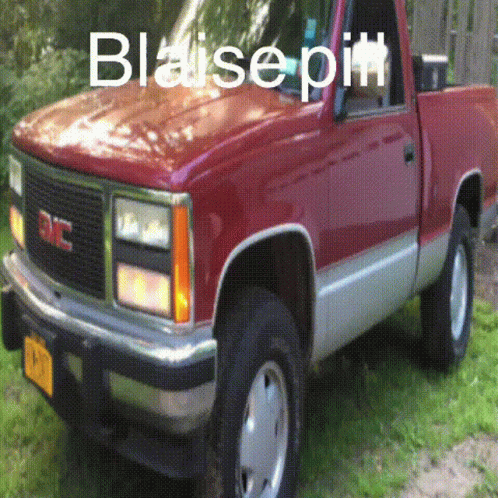A Red Gmc Truck Is Parked On The Grass GIF