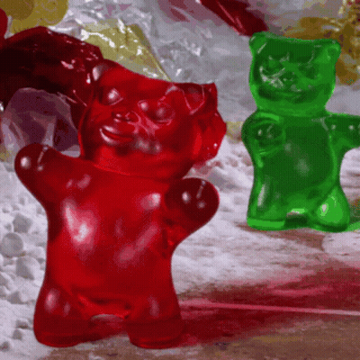 A Red Gummy Bear And A Green Gummy Bear GIF