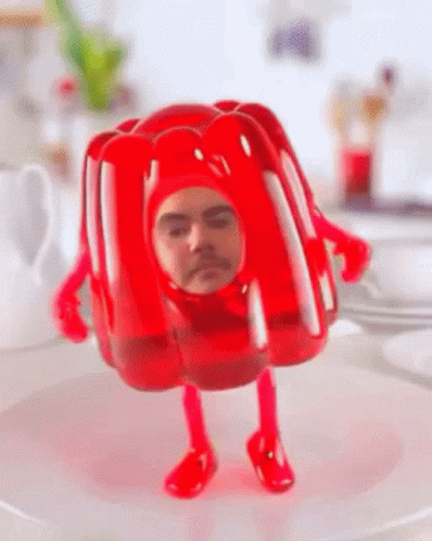 A Red Jelly Figurine With A Man 'S Face On It GIF