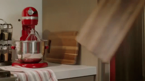 A Red Kitchenaid Mixer Is On A Kitchen Counter GIF