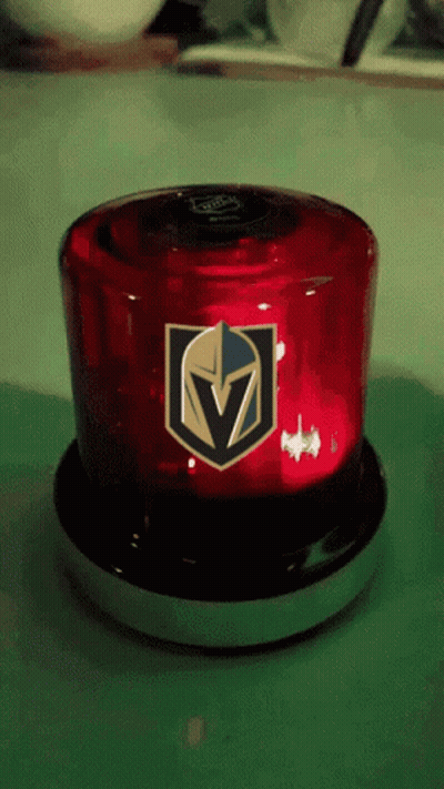 A Red Light With A Golden Knights Logo On It Sits On A Table GIF
