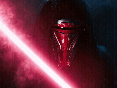 A Red Lightsaber Is Being Held By A Person In A Dark Room GIF