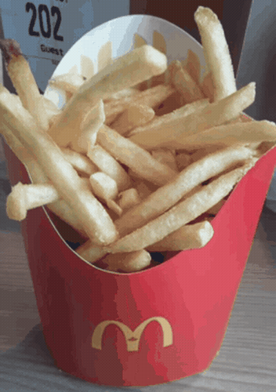 A Red Mcdonald 'S Box Filled With French Fries Sits On A Table GIF