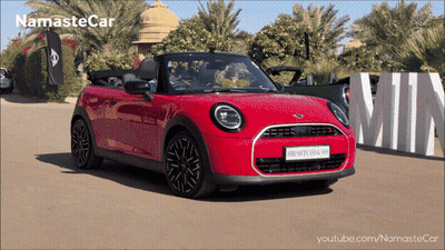 A Red Mini Convertible Is Parked In Front Of A Sign That Says Min GIF