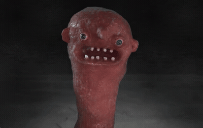 A Red Monster With A Blue Eye And White Teeth Is Looking At The Camera GIF