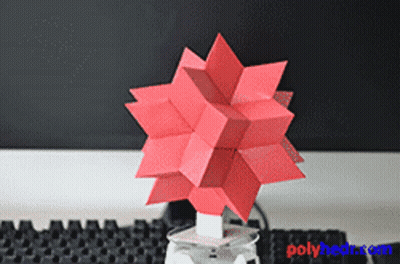A Red Origami Object Is Sitting On A Table Next To A Keyboard GIF