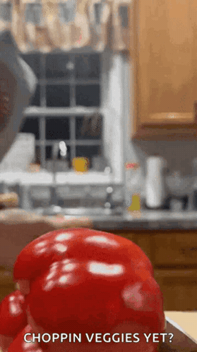A Red Pepper Is Sitting On A Cutting Board In A Kitchen With The Words Choppin Veggies Yet Below It GIF