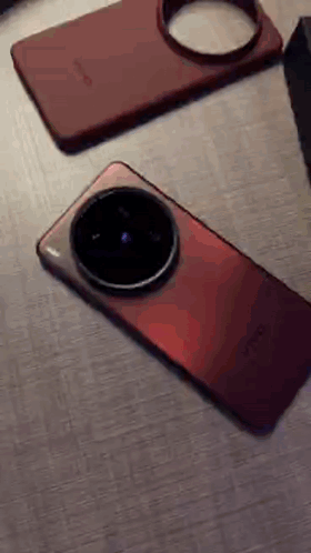 A Red Phone Is Laying On A Table Next To A Box GIF