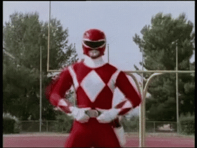 A Red Power Ranger Is Standing On A Track With His Arms Crossed . GIF