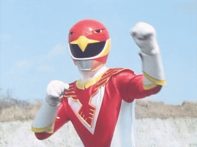 A Red Power Ranger With A Bird On His Helmet Is Standing In Front Of A Blue Sky With His Arms Outstretched . GIF