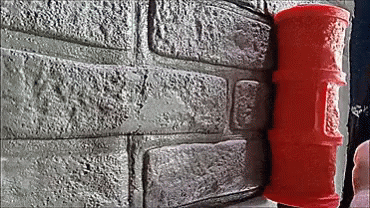A Red Roller Is Sitting On A Brick Wall Next To A Brick Wall . GIF