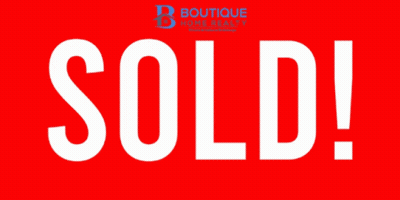 A Red Sign That Says Sold In White Letters On It GIF
