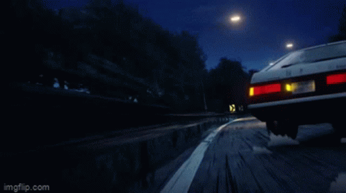 A Red Sports Car And A White Sports Car Are Driving Down A Road GIF