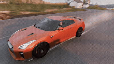 A Red Sports Car Is Driving Down A Road With A White House In The Background GIF
