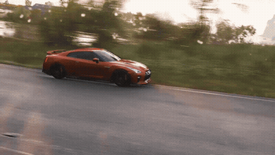 A Red Sports Car Is Driving Down The Road GIF