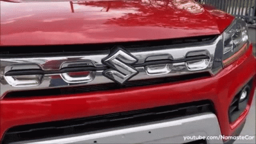 A Red Suzuki Car Is Parked On The Street GIF