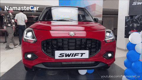 A Red Swift Car Is Displayed At A Dealership GIF