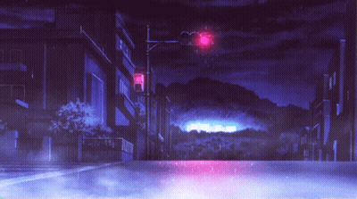 A Red Traffic Light Is Lit Up At Night In A City GIF