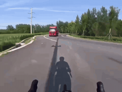 A Red Truck Driving Down A Road With A Shadow Of A Person On The Ground GIF