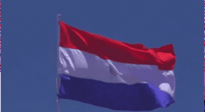 A Red White And Blue Flag Flies In The Wind GIF
