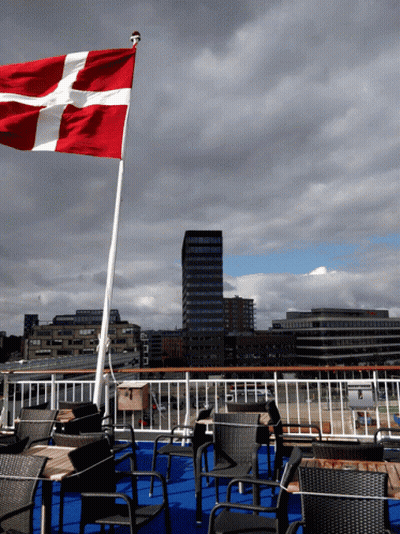 A Red White And Blue Flag Is Flying In The Wind On A Cloudy Day GIF