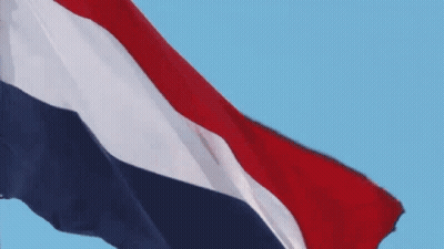 A Red White And Blue Flag Waving In The Wind GIF