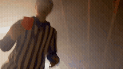 A Referee In A Striped Shirt Is Holding A Red Card In His Hand . GIF