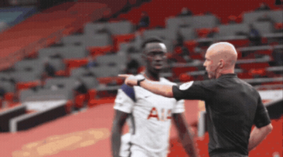 A Referee Is Pointing At A Soccer Player Who Is Wearing A Tottenham Shirt GIF
