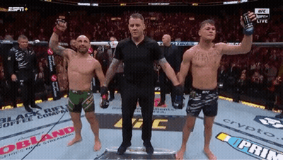 A Referee Is Standing Between Two Men In A Boxing Ring . GIF