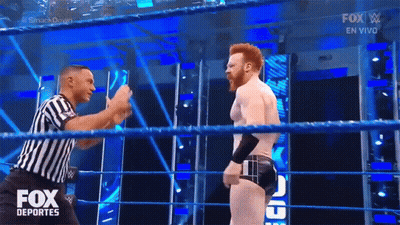 A Referee Is Standing In A Wrestling Ring Talking To A Wrestler During A Fox Deportes Show GIF