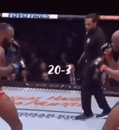 A Referee Is Standing In The Middle Of A Boxing Match With The Number 20-3 Written On The Screen . GIF