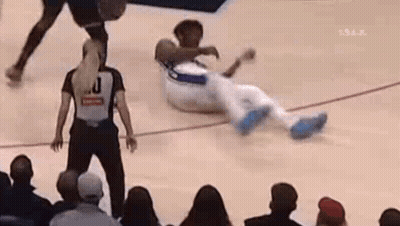 A Referee Is Standing Next To A Basketball Player On The Court . GIF