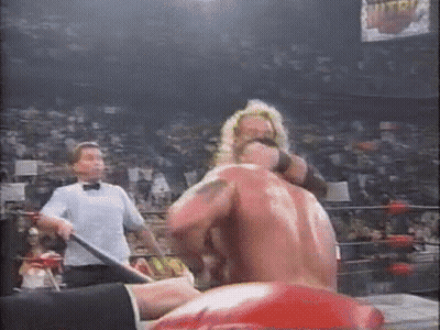 A Referee Is Standing Next To A Wrestler In A Ring . GIF