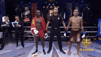 A Referee Stands Between Two Boxers One Of Whom Is Wearing A Pereira Shirt GIF