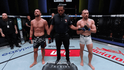 A Referee Stands Between Two Fighters In A Boxing Ring GIF