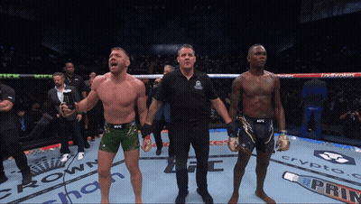 A Referee Stands Between Two Fighters In A Boxing Ring Sponsored By Crypto Com GIF