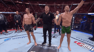 A Referee Stands Between Two Fighters On A Boxing Ring GIF