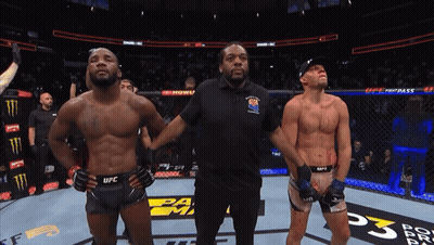 A Referee Stands Between Two Ufc Fighters On A Boxing Ring GIF