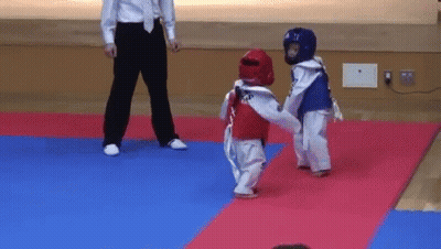 A Referee Stands Between Two Young Karate Players GIF