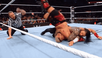 A Referee Watches A Wrestling Match Between Two Wrestlers GIF